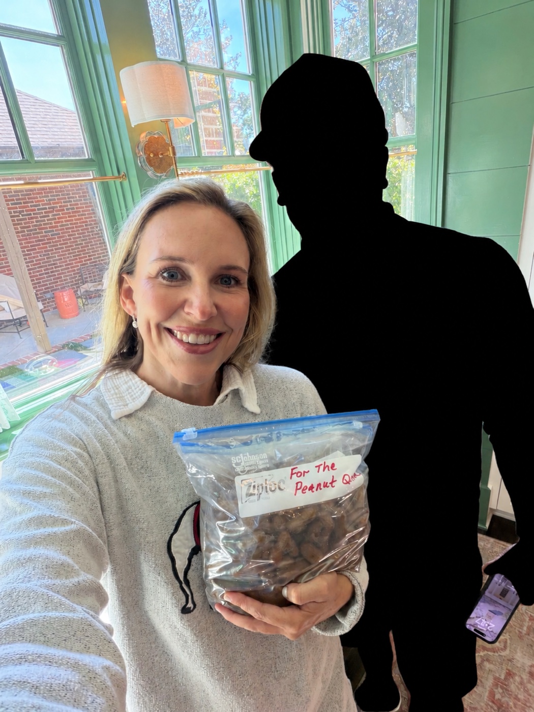A woman holding boiled peanuts beside a man shown as a black silhouette